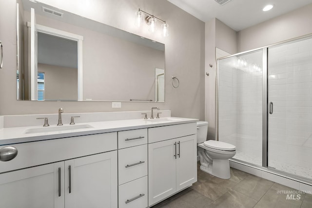 full bathroom with a stall shower, toilet, visible vents, and a sink