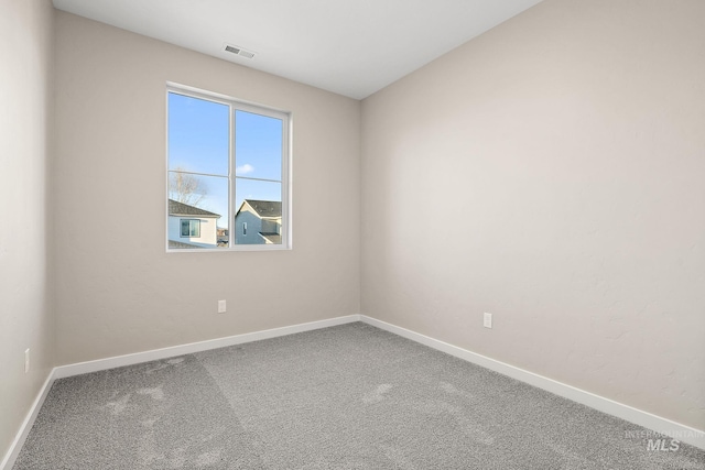 carpeted empty room featuring visible vents and baseboards