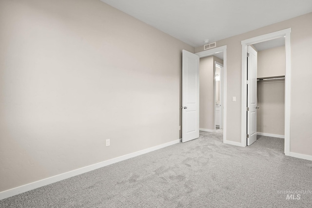 unfurnished bedroom with carpet, visible vents, a closet, and baseboards