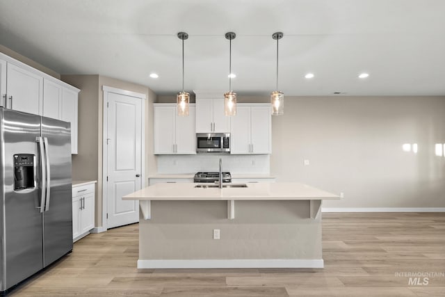 kitchen with tasteful backsplash, stainless steel appliances, light countertops, and a sink