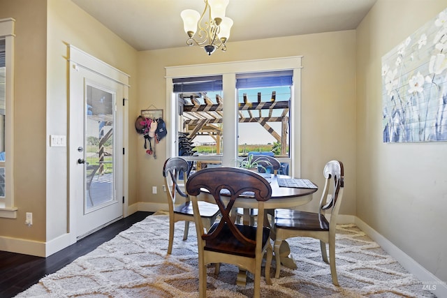 dining room featuring a chandelier, dark wood finished floors, and baseboards