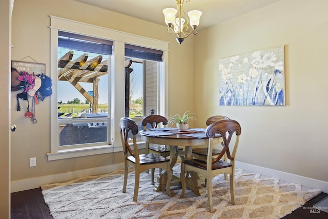 dining room with an inviting chandelier, baseboards, and wood finished floors