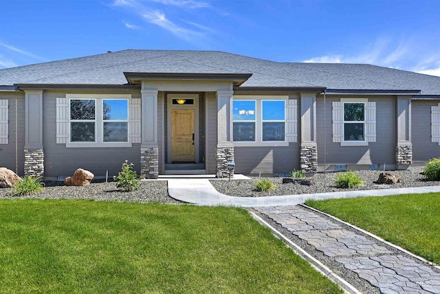 view of front of house featuring a front lawn and roof with shingles