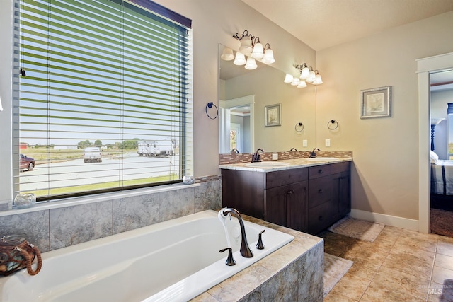 bathroom with double vanity, tile patterned flooring, a sink, and a bath