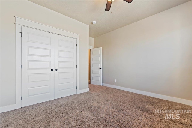 unfurnished bedroom featuring carpet floors, a ceiling fan, baseboards, and a closet