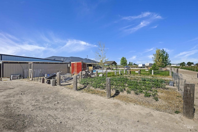 view of front of property with an outdoor structure and fence