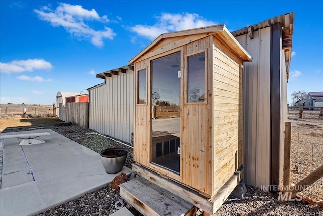 view of outdoor structure featuring an outbuilding and fence