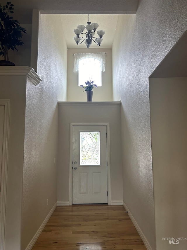 entrance foyer with wood-type flooring and an inviting chandelier