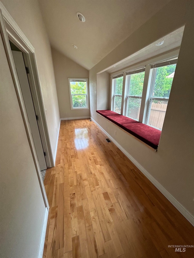 unfurnished room with vaulted ceiling and light hardwood / wood-style flooring