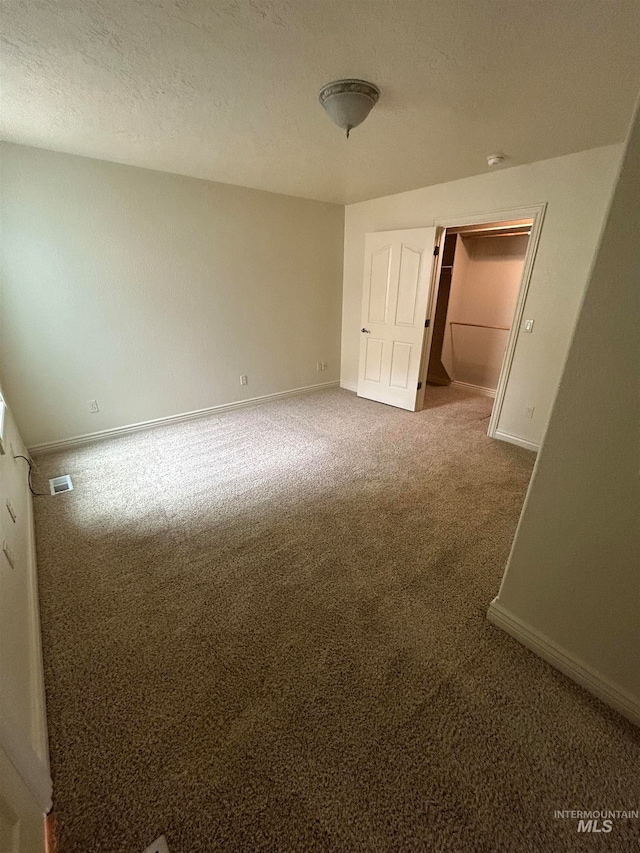 spare room featuring carpet floors and a textured ceiling