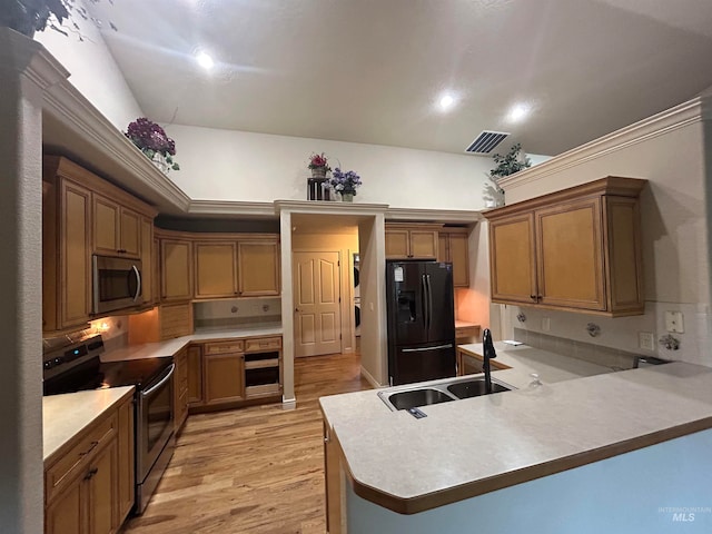 kitchen featuring electric range oven, sink, kitchen peninsula, light hardwood / wood-style floors, and black refrigerator