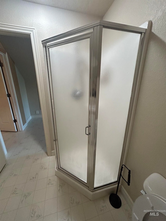 bathroom featuring walk in shower, lofted ceiling, and tile patterned floors