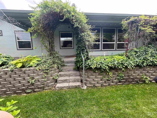 entrance to property featuring a lawn