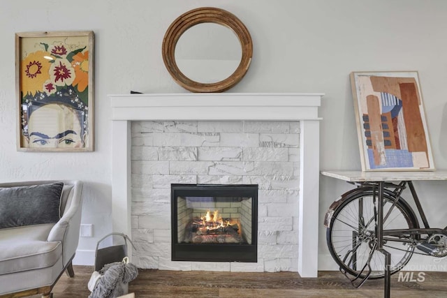 detailed view of a warm lit fireplace and wood finished floors