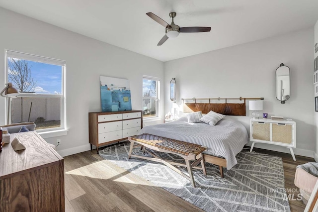 bedroom featuring wood finished floors, baseboards, and a ceiling fan