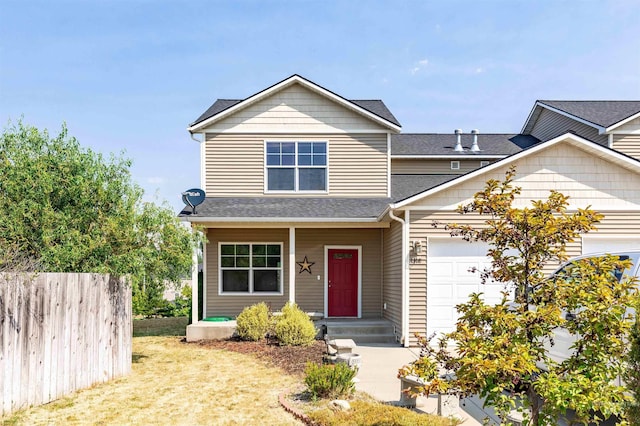 view of front of property with roof with shingles, fence, and an attached garage