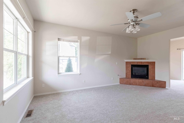 unfurnished living room featuring a fireplace, carpet, and ceiling fan