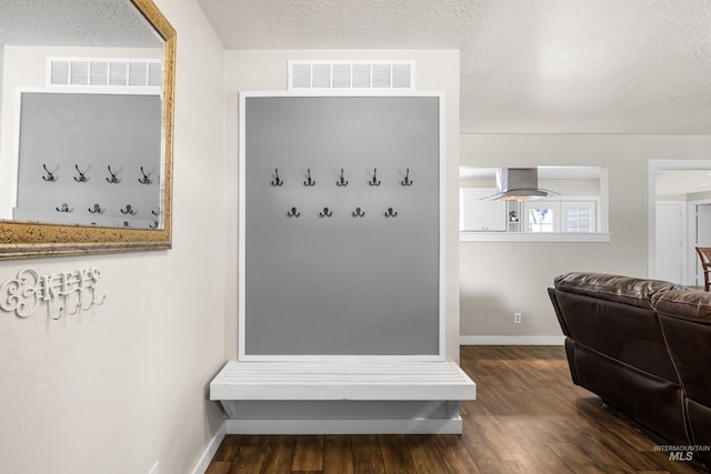 mudroom featuring a textured ceiling, baseboards, visible vents, and dark wood-style floors