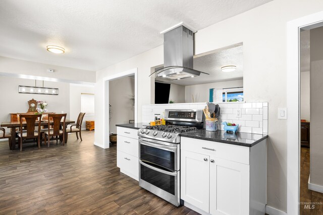 kitchen with dark countertops, island range hood, dark wood-style flooring, and range with two ovens