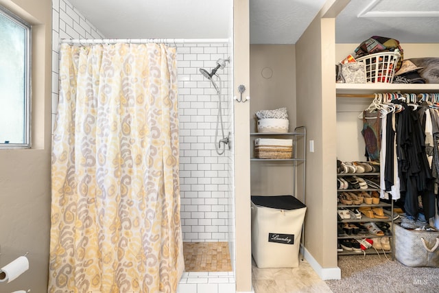 full bath with a tile shower and a spacious closet