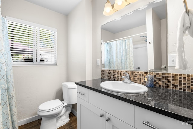 full bathroom with vanity, toilet, baseboards, decorative backsplash, and wood finished floors