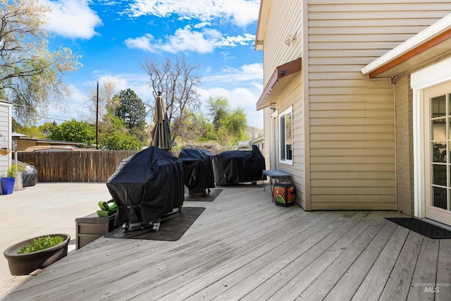 deck with grilling area, a patio, and fence