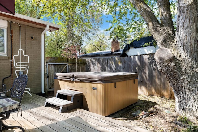 wooden terrace with a hot tub and fence