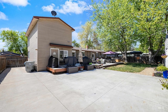 rear view of house with a fenced backyard, a patio area, and a yard