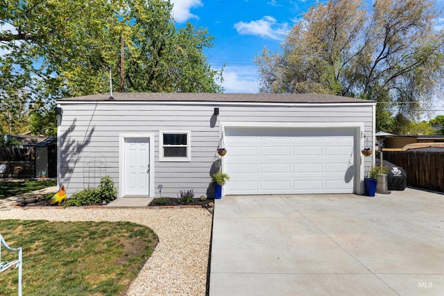 garage featuring fence and driveway