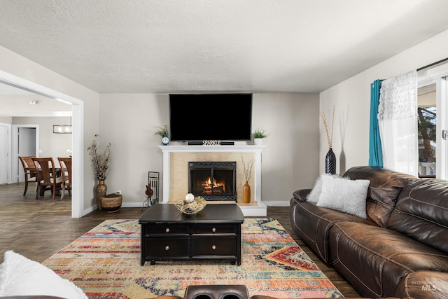 living room with a high end fireplace, baseboards, and wood finished floors