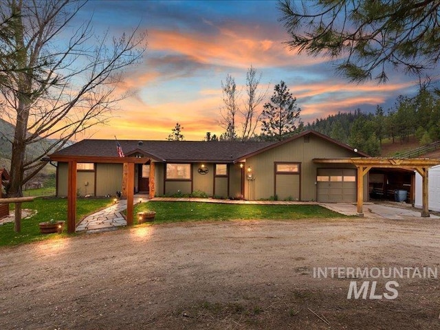 view of front of home featuring a lawn, an attached garage, driveway, and a carport