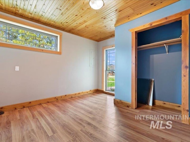 unfurnished bedroom with wooden ceiling, baseboards, a closet, and wood finished floors