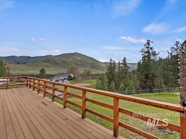 wooden deck with a lawn, a mountain view, and fence