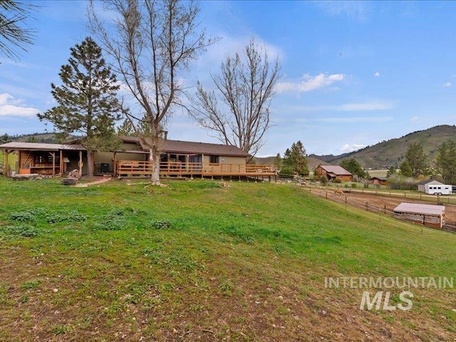 rear view of house with a mountain view, an outdoor structure, and an exterior structure