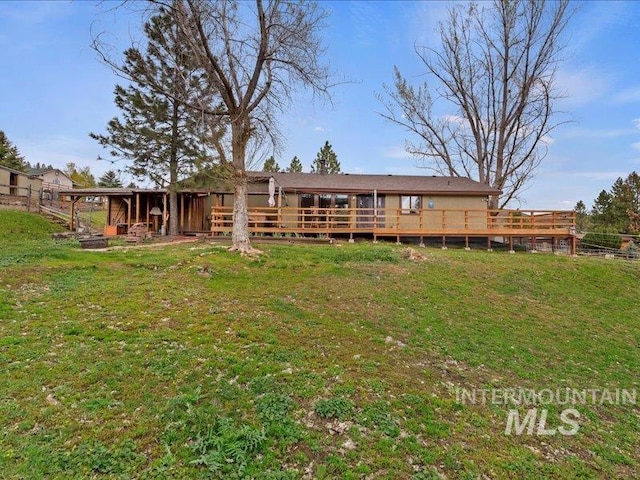 back of property with a lawn and a wooden deck