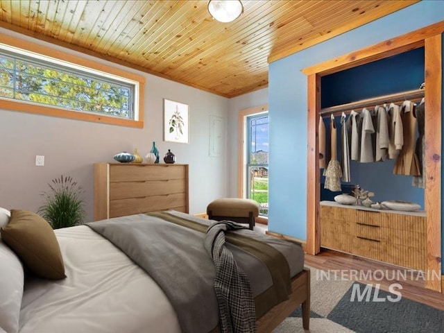 bedroom with wood ceiling, wood finished floors, and a closet