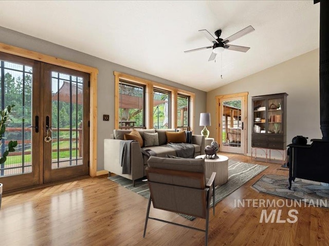 living room with a wealth of natural light, french doors, wood finished floors, and lofted ceiling