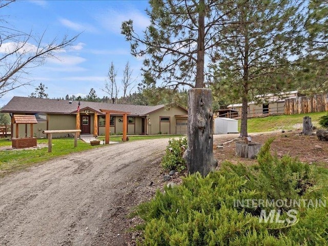 view of front of property featuring fence, an attached garage, and driveway
