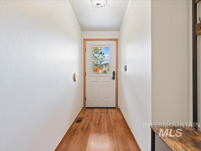 entryway featuring light wood-style floors, baseboards, and visible vents