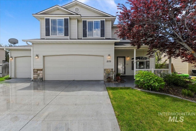 2175 W Willow Pointe Ave, Nampa, ID 83651 - view of front facade with concrete driveway, covered porch, an attached garage, stone siding, and a front lawn