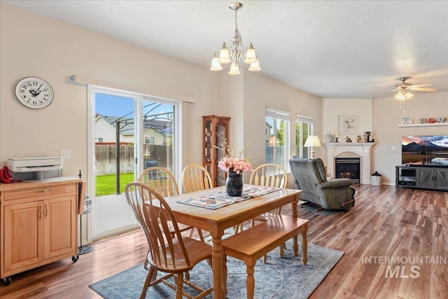 2175 W Willow Pointe Ave, Nampa, ID 83651 - dining space featuring a chandelier, light wood-style floors, a fireplace, and ceiling fan