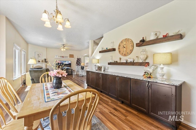 2175 W Willow Pointe Ave, Nampa, ID 83651 - dining room featuring wood finished floors, a fireplace, a chandelier, plenty of natural light, and a textured ceiling