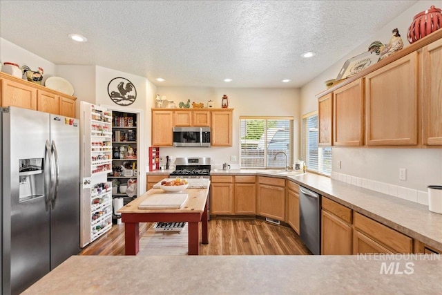 2175 W Willow Pointe Ave, Nampa, ID 83651 - kitchen with appliances with stainless steel finishes, light wood-style floors, a textured ceiling, light brown cabinets, and recessed lighting