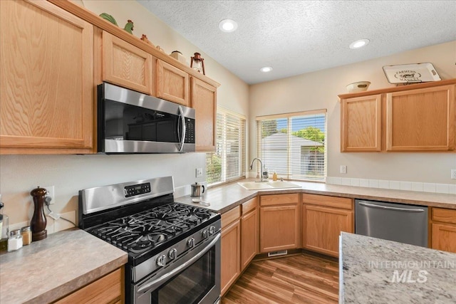 2175 W Willow Pointe Ave, Nampa, ID 83651 - kitchen with stainless steel appliances, a sink, a textured ceiling, light countertops, and wood finished floors