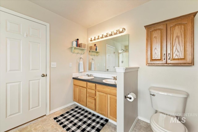 2175 W Willow Pointe Ave, Nampa, ID 83651 - bathroom featuring baseboards, toilet, double vanity, and an enclosed shower