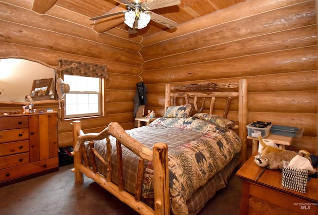 bedroom featuring carpet flooring, ceiling fan, wood ceiling, and rustic walls