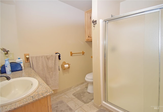 bathroom featuring tile patterned flooring, vanity, a shower with shower door, and toilet