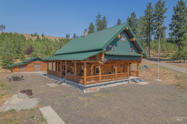 log cabin with an outbuilding, a porch, and a garage