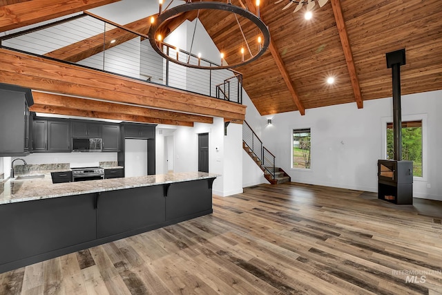 1 Caribou Pkwy, Cascade, ID 83611 - kitchen featuring appliances with stainless steel finishes, high vaulted ceiling, a sink, light stone counters, and a peninsula