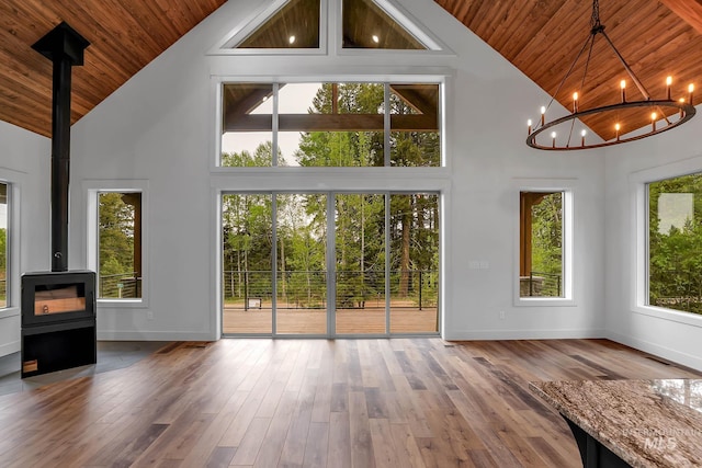 1 Caribou Pkwy, Cascade, ID 83611 - unfurnished living room with wood ceiling, high vaulted ceiling, a wood stove, a chandelier, and baseboards